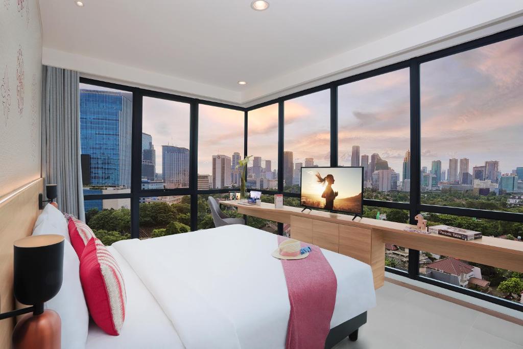 1 dormitorio con 1 cama y TV en una habitación con ventanas en Citadines Gatot Subroto Jakarta en Yakarta