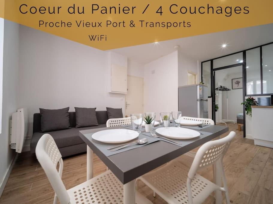 Appartement tout équipé au coeur du Panier Vieux Port في مارسيليا: طاولة طعام وكراسي في غرفة المعيشة