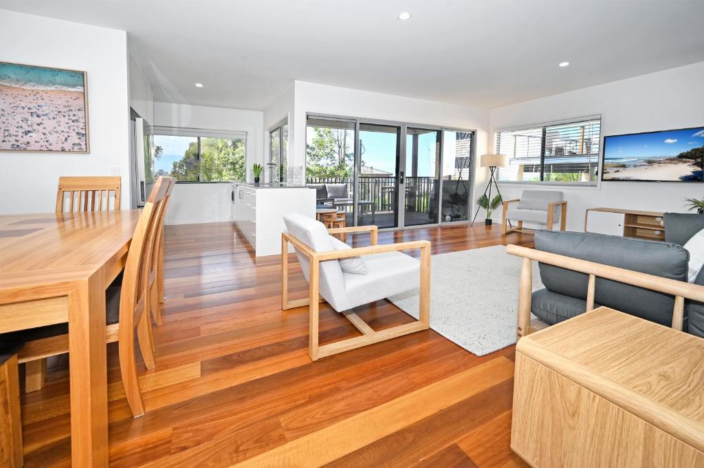 a dining room and living room with a table and chairs at Spacious New 2 bedroom Kings Beach Townhouse ZF2 in Caloundra