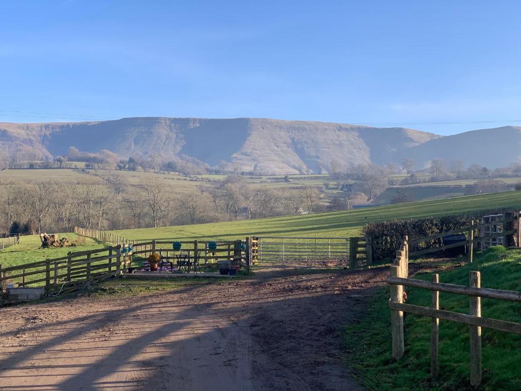 a dirt road with a fence and mountains in the background at Black Mountain Views in Velindre