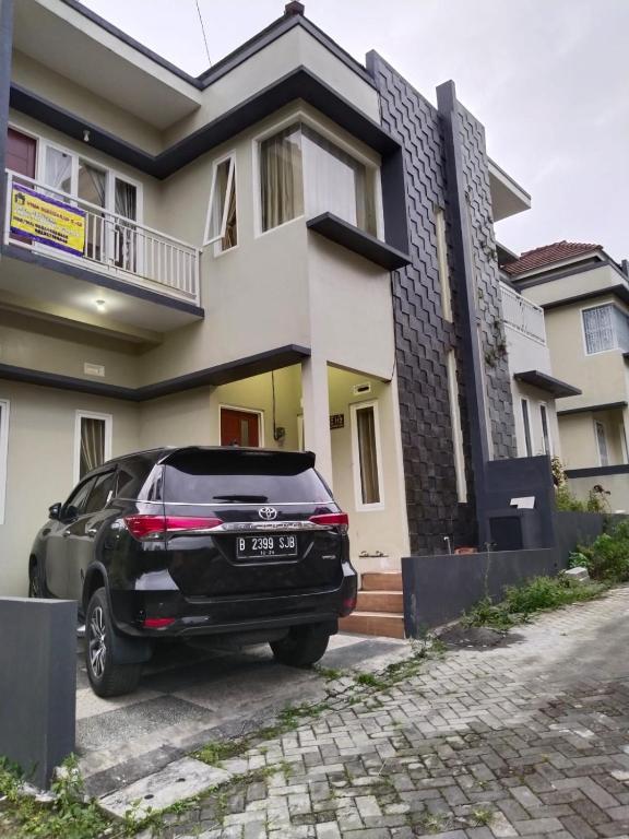um carro preto estacionado em frente a uma casa em Villa keluarga sejahtera em Batu