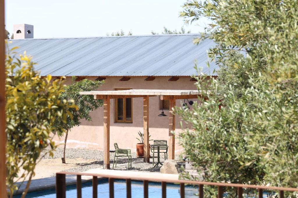a house with a black roof with chairs in front of it at Alma Liebre Viñedos del Valle in Valle de Guadalupe