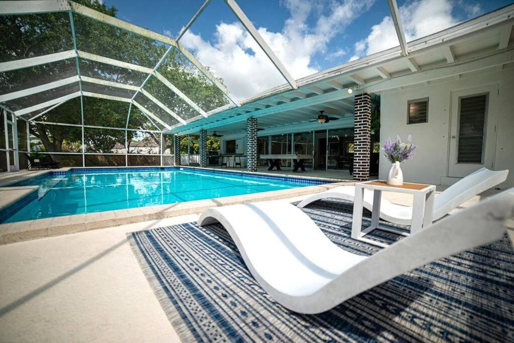 uma piscina com mesa e cadeiras ao lado de uma casa em Luxury Miami Village w/Pool+Grill+MiniGolf em Miami