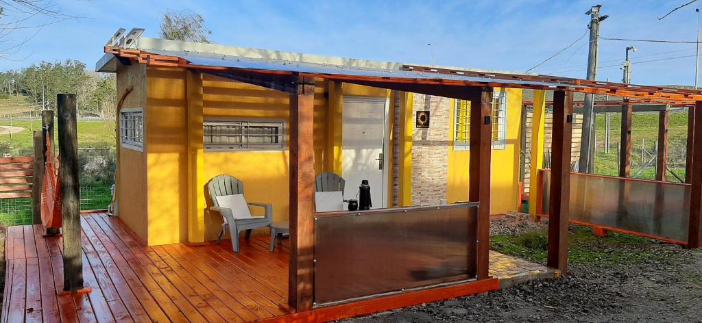 ein kleines Haus auf einer Terrasse mit einem Tisch und Stühlen in der Unterkunft Descanso Milac Navira in Minas