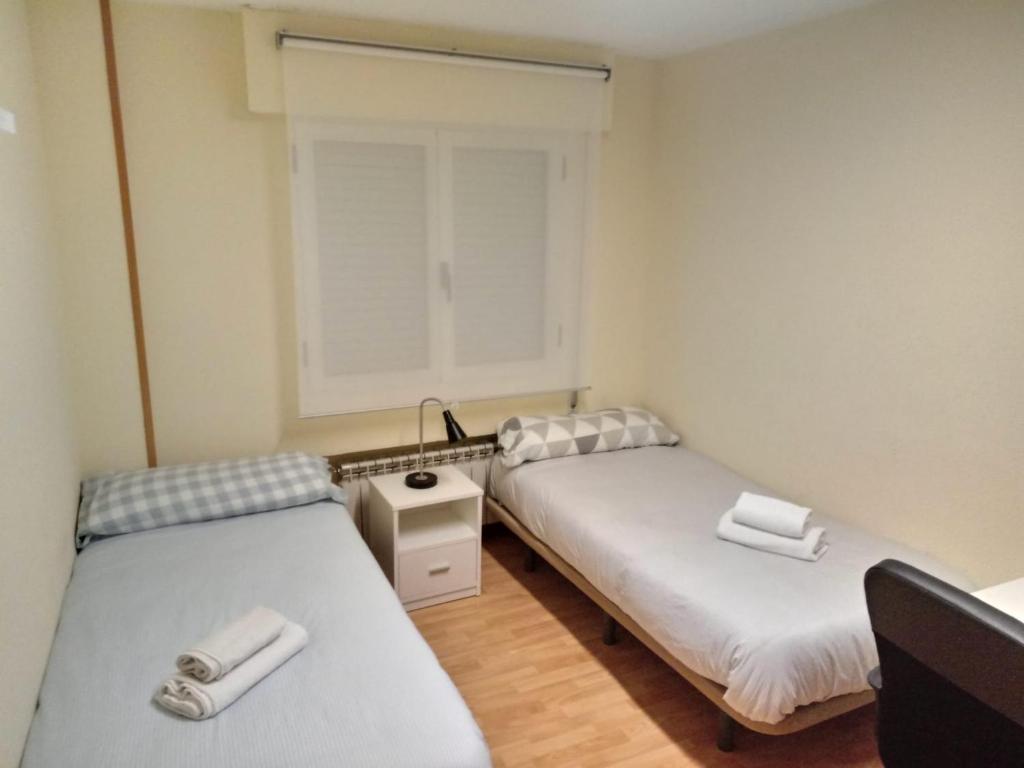 two beds in a small room with a window at Room in Guest room - H Individual In Reformed Residence wifi center in Madrid
