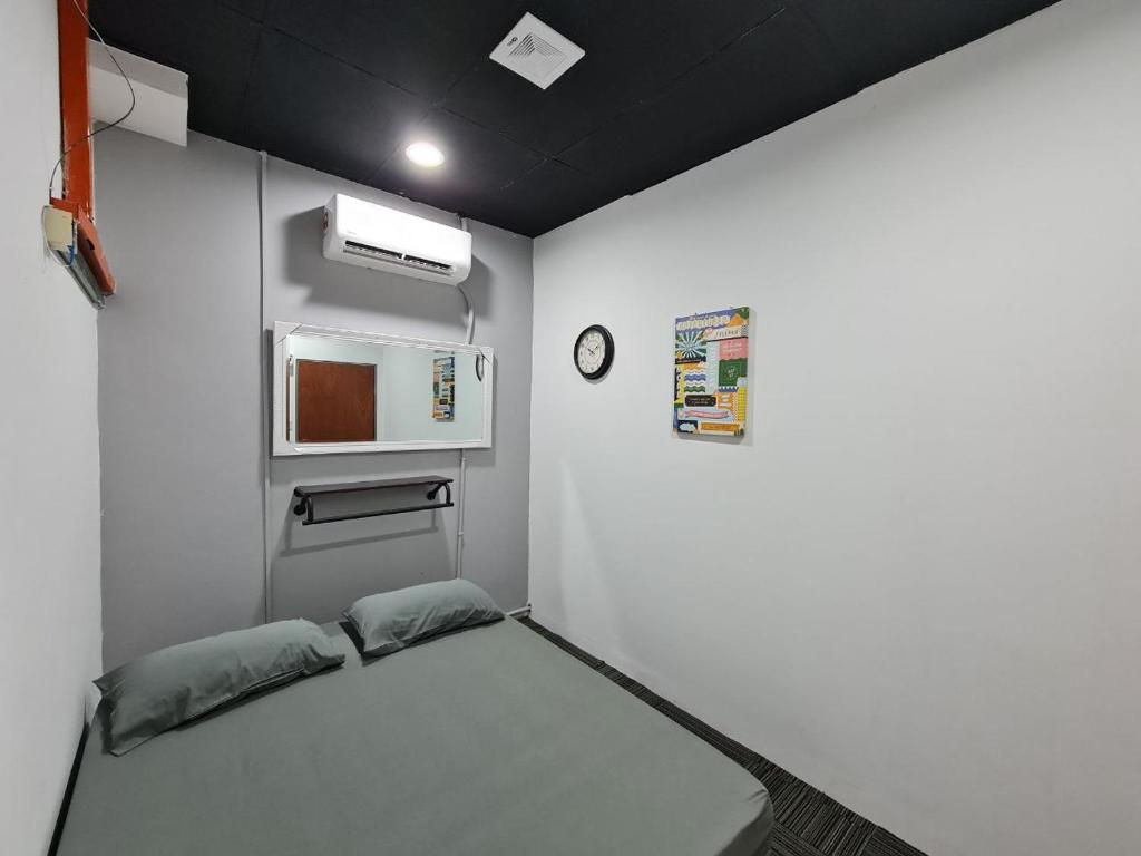 Habitación pequeña con cama y microondas. en Ayden Hostel Airport Transit - KLIA, en Sepang