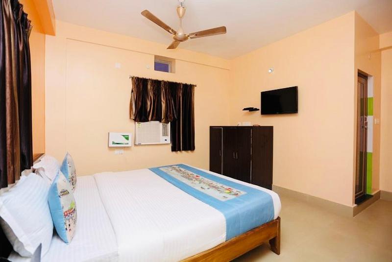 a bedroom with a bed and a ceiling fan at Krishna Residency ! Puri in Puri