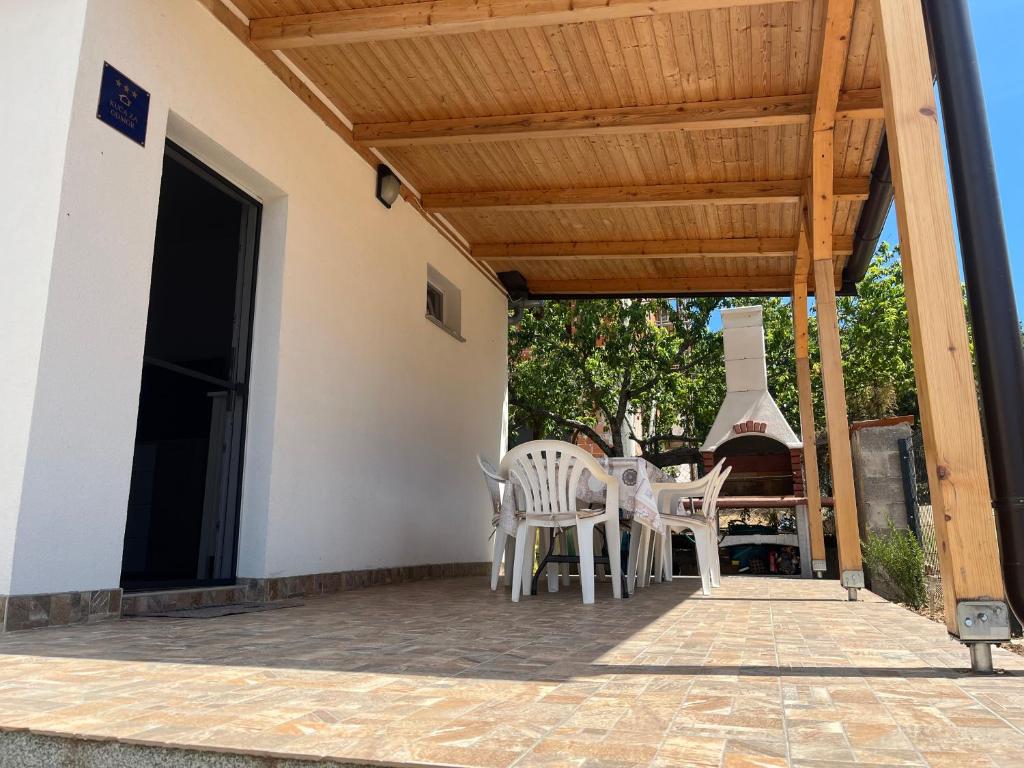 a patio with chairs and a table and a stove at Holiday House Sanja Private Terrace BBQ in Peaceful Surroundings in Medulin