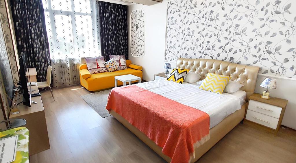 ein Schlafzimmer mit einem Bett und einem Sofa darin in der Unterkunft Apartment with panoramic view in the center in Bischkek
