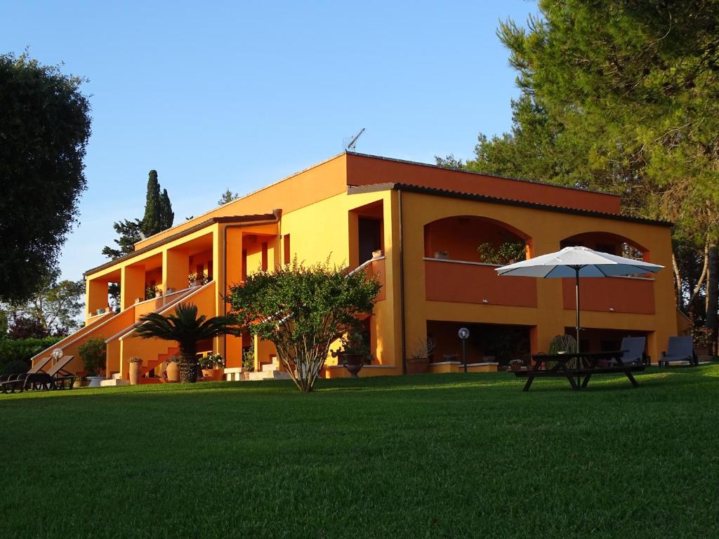 un edificio amarillo con un paraguas en un patio en Sole del Mediterraneo en Otranto