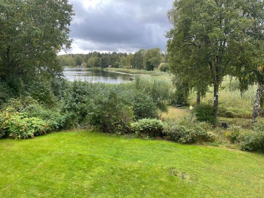 a view of a river from a yard with a grass field at Nyrenoverat strandnära med fantastisk utsikt in Rimbo