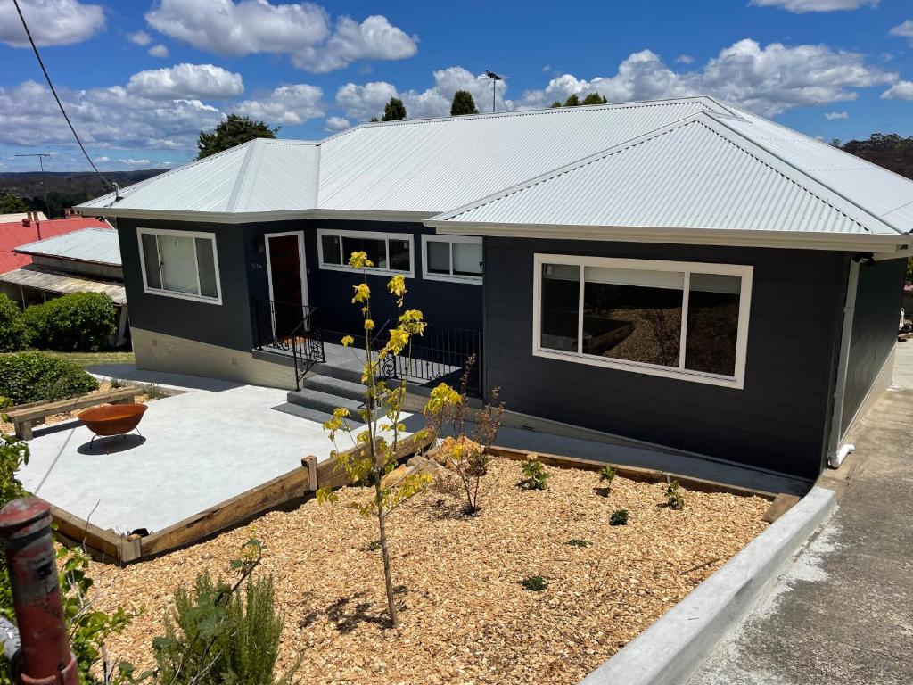 a blue tiny house with a yard at Heart of Katoomba Semi 1 bedroom home in Katoomba