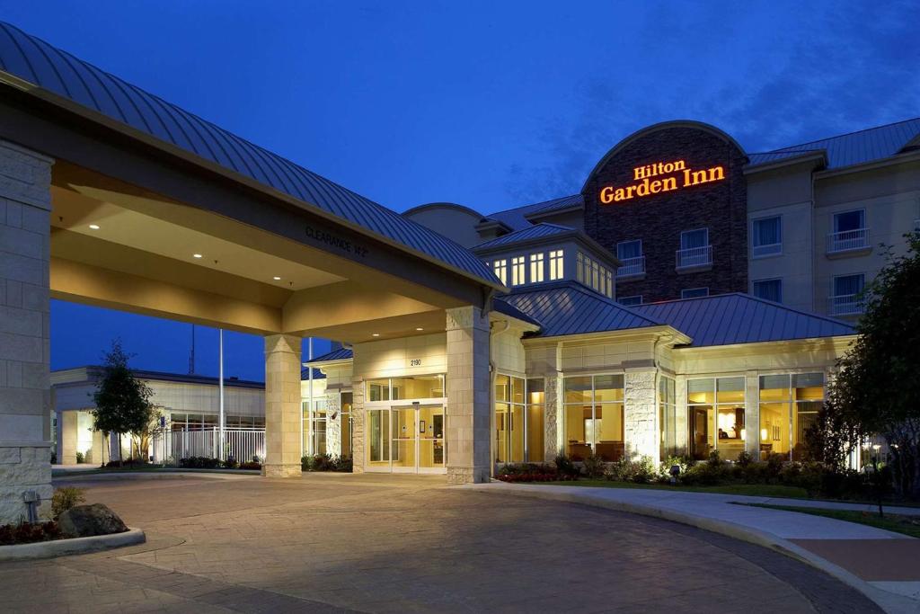 Hilton Garden Inn Dallas Arlington في أرلينغتون: فندق فيه لافته مكتوب عليها نزل السفارات والحديقة