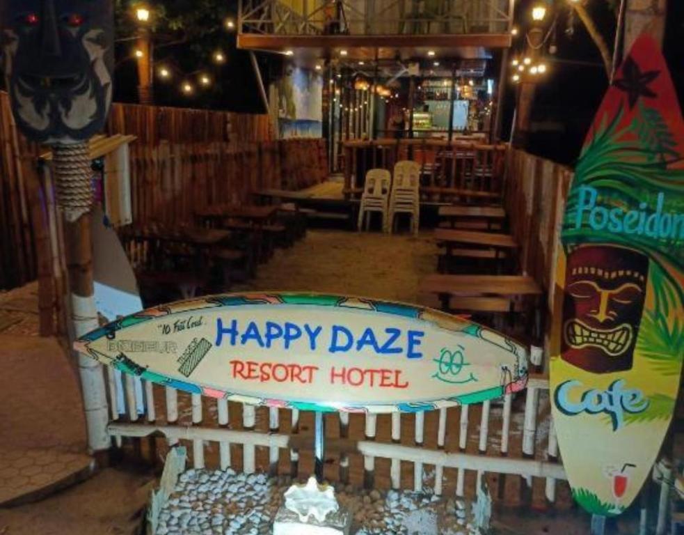 una tabla de surf sentada en una valla en un restaurante en Happy Daze Resort Hotel, 