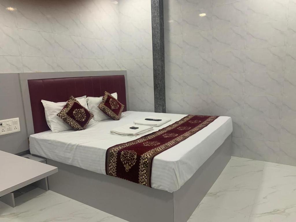 a bed in a white room with at Hotel Sai Plaza, Chembur Mumbai in Mumbai