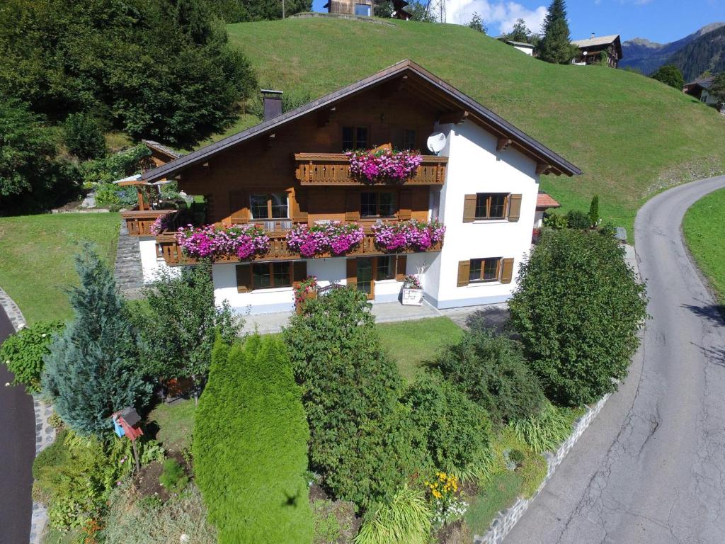 une maison sur une colline avec des fleurs sur le balcon dans l'établissement Haus Baleisa, à Gaschurn