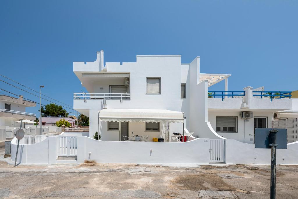 una casa blanca con una valla blanca delante de ella en Casa vacanze Pescoluse, en Marina di Pescoluse
