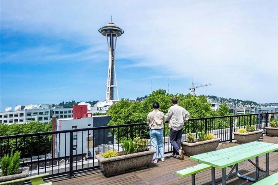twee personen op een balkon met uitzicht op een toren bij 1BR Condo, Air Conditioning, FREE Parking, Rooftop View in Seattle