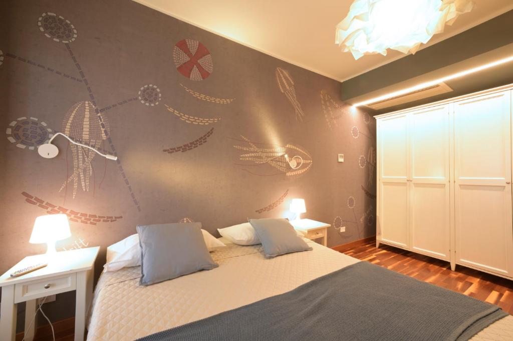 ein Schlafzimmer mit einem Bett und einer Wand mit Zeichnungen darauf in der Unterkunft Hotel Bristol in Alassio