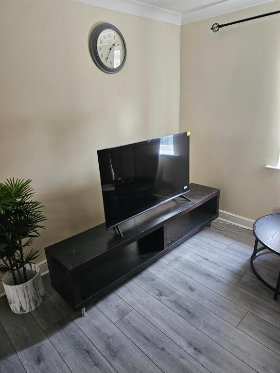 een woonkamer met een flatscreen-tv op een zwart entertainmentcentrum bij 3/4 bedrooms, Free Parking, Wifi, Home away from home feel in Purfleet