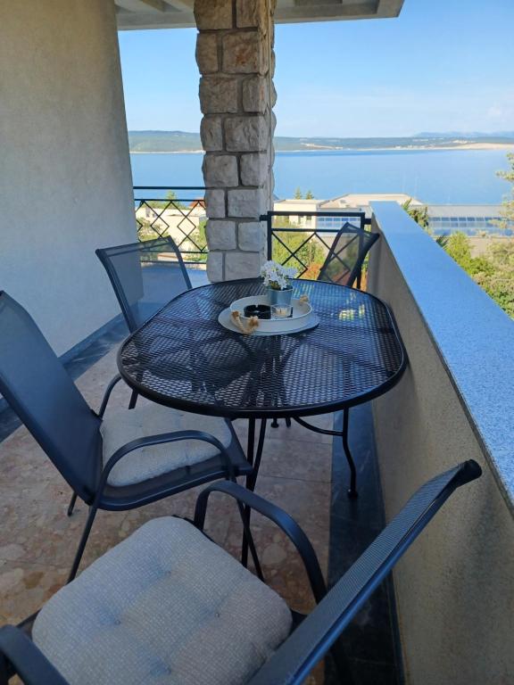 a table and chairs on a balcony with the ocean at Helen Apartments in Crikvenica