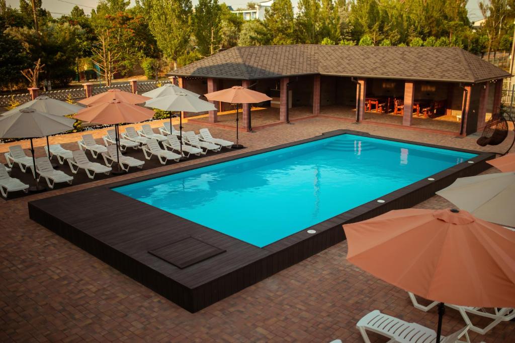 an overhead view of a swimming pool with chairs and umbrellas at REEF Hotel in Koblevo