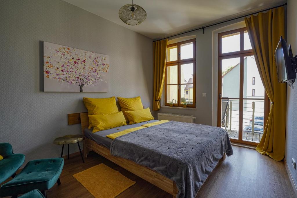 um quarto com uma cama com almofadas amarelas e uma janela em Abendsonne em Naumburg