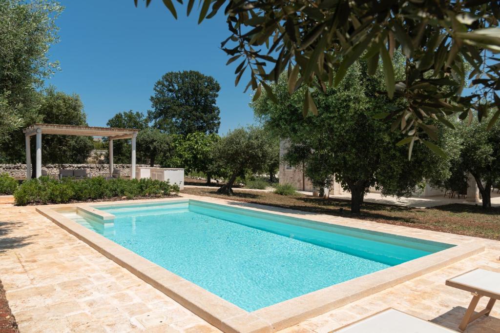 una piscina in un cortile con un albero di Villa Solivetta a Martina Franca