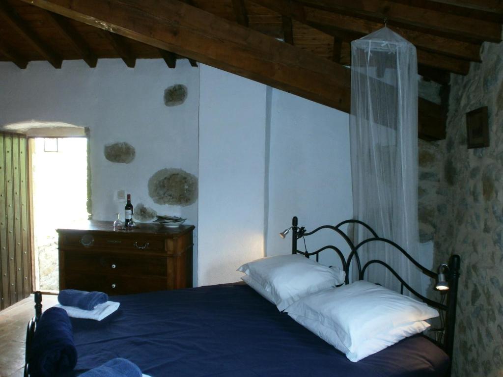 1 dormitorio con cama azul y almohadas blancas en Gîte Donjon en La Répara