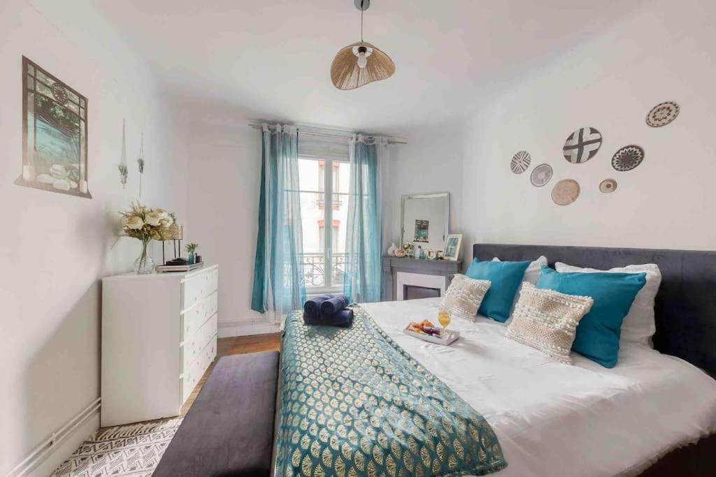 - une chambre avec un grand lit et des oreillers bleus dans l'établissement Jacuzzi extérieur à 15 min de Paris*, à Rosny-sous-Bois