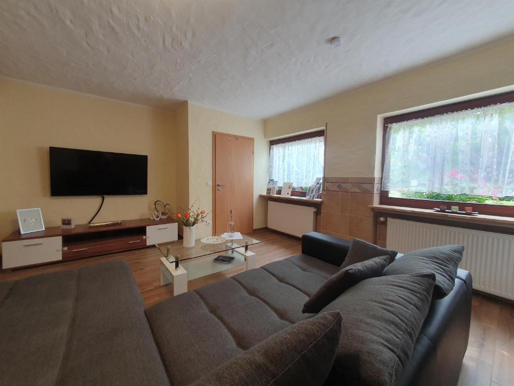 a living room with a couch and a flat screen tv at Ferienwohnung Moselglück in Burgen