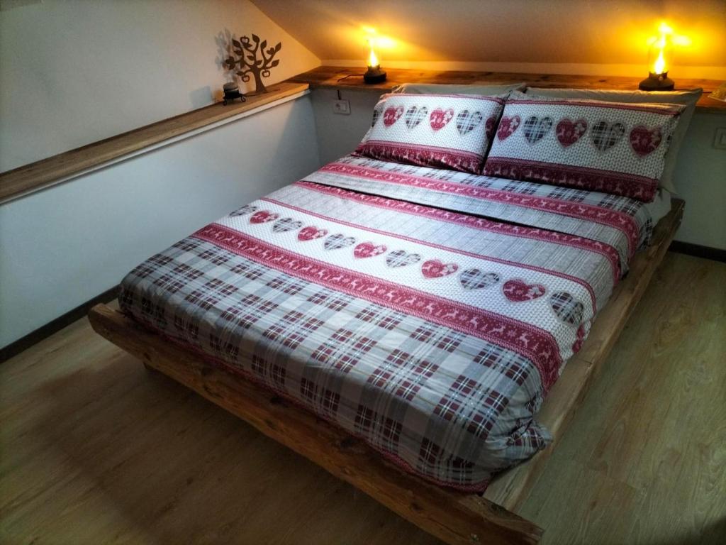 uma cama num quarto com duas lâmpadas na parede em AlBy&B em Arnoldstein