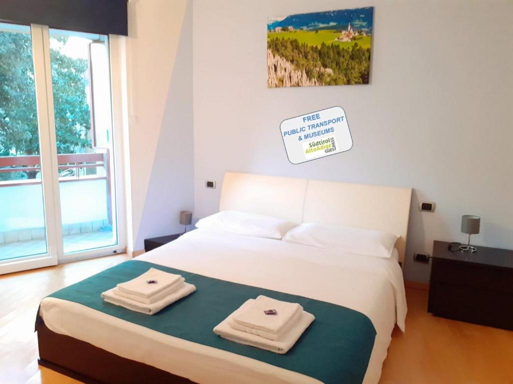 a bedroom with a bed with two towels on it at Appartamento ospitale in Bolzano