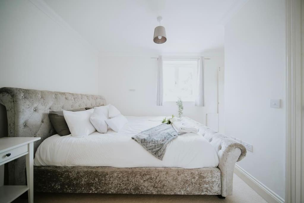 - un lit avec des draps et des oreillers blancs dans une chambre dans l'établissement Linen Cottage- Parking, LEDs, 4K TVs, 5G WIFI and more!, à Bath