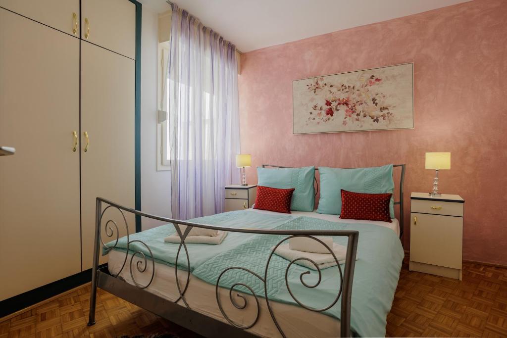 1 dormitorio con 1 cama con almohadas azules y rojas en Center Apartment Silvana, en Split