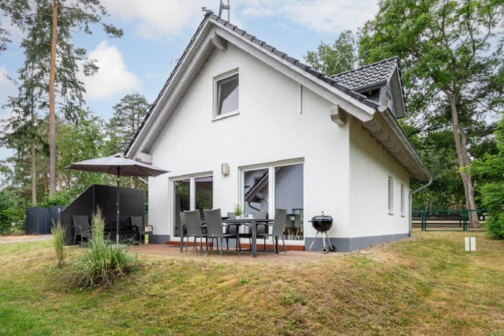 a white house with a patio and a grill at Ferienhaus Alpaka in Plau am See