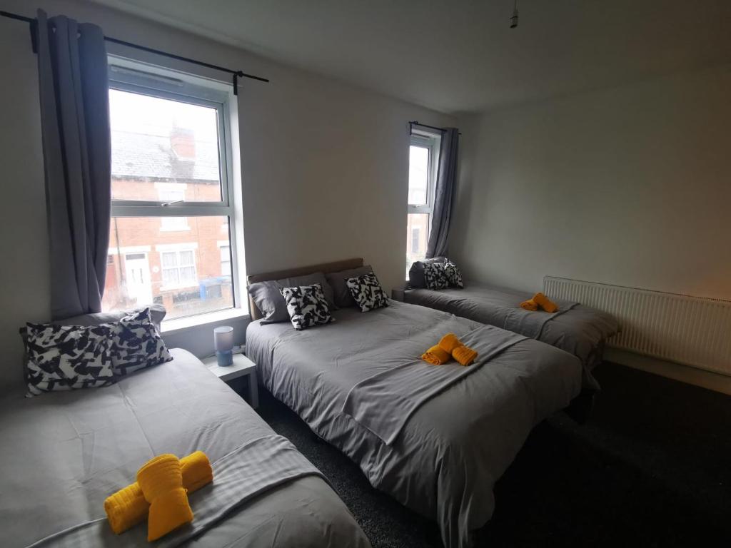 a bedroom with two beds with teddy bears on them at Sutherland Place - Near Derby City Center in Derby