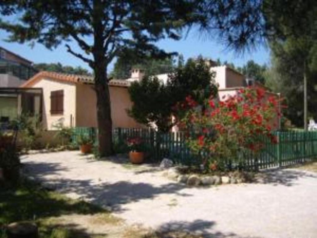 アルジェレス・シュル・メールにあるles Oiseaux - Pinède avec piscineの塀と木と花の家