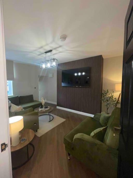 a living room with two green couches and a tv at Churchview Apartments in Seaham