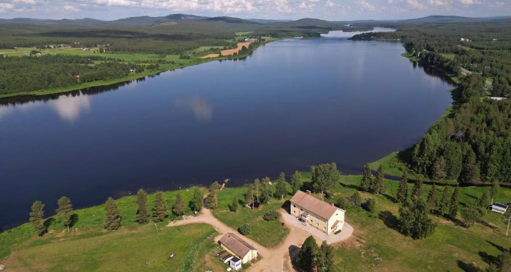 an aerial view of a lake with a house at Napapiirin Eräkartano in Pello