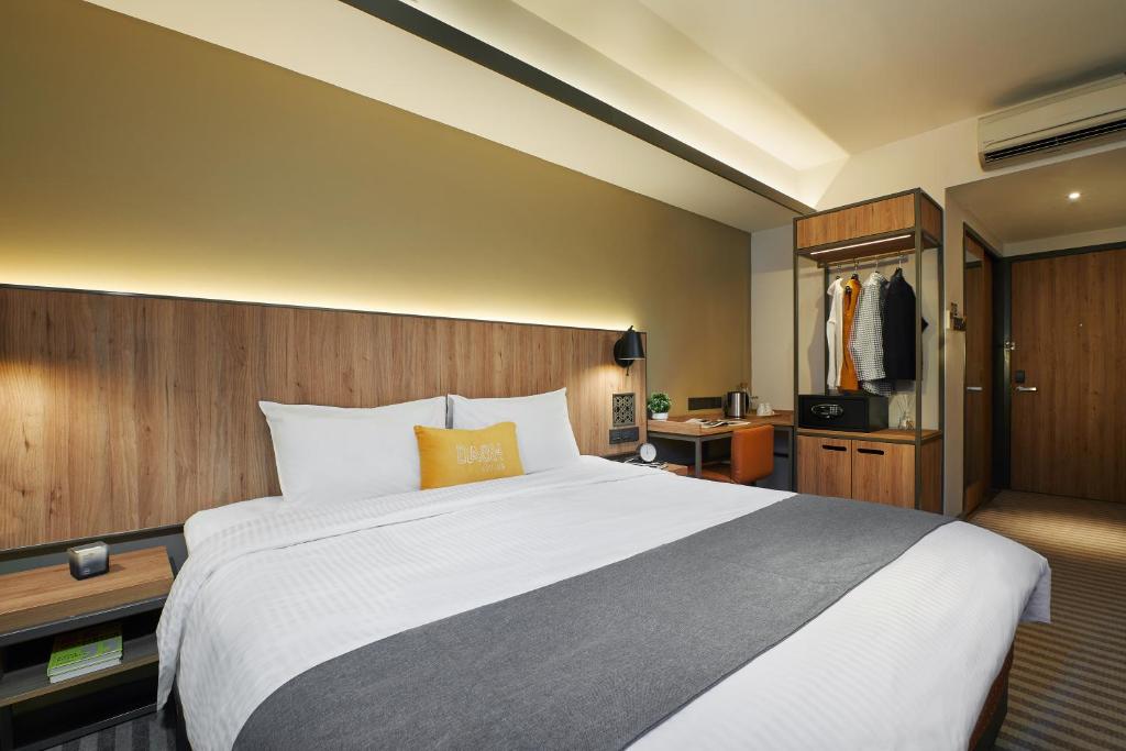 a hotel room with a large bed and a desk at Dash Living Rochor in Singapore