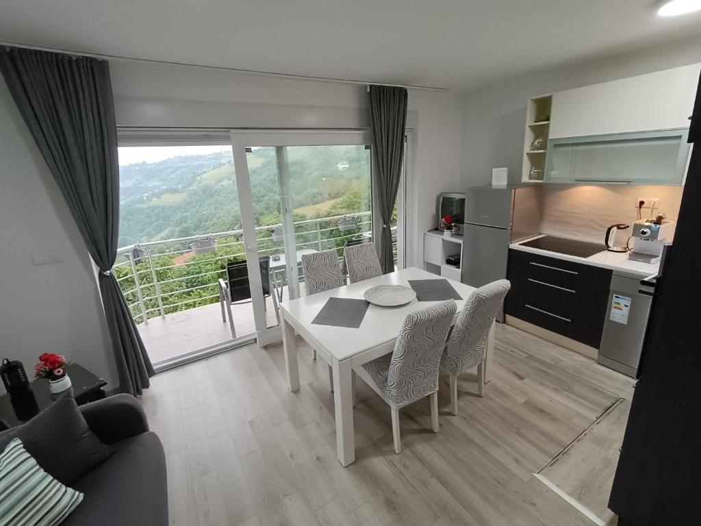 a kitchen with a white table and chairs in a room at Nahorevska vikendica in Sarajevo