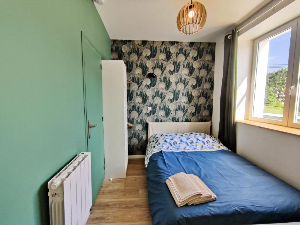 um pequeno quarto com uma cama azul e uma janela em Chambre Rousig avec salle de bains privative dans une résidence avec salon et cuisine partagés em Brest