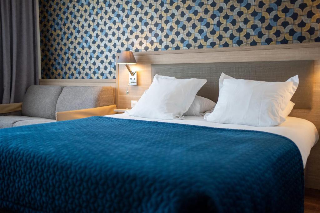 a hotel room with a large bed and a couch at Campanile Troyes Nord - Barberey in Troyes