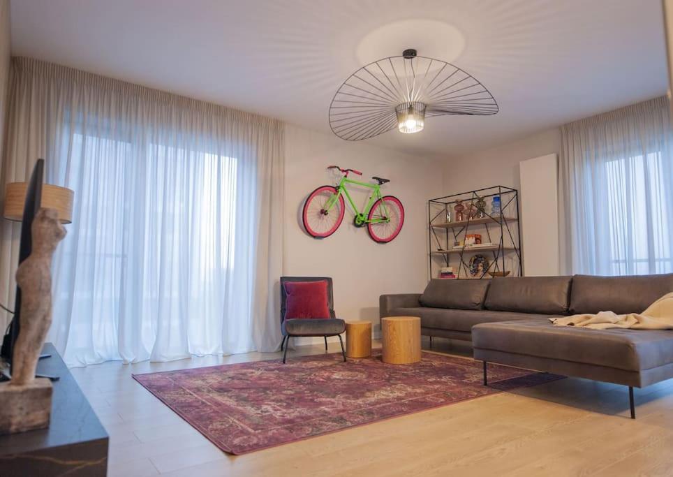 ein Wohnzimmer mit Sofa und Fahrrad an der Wand in der Unterkunft Shades of Grey 124 in Bukarest