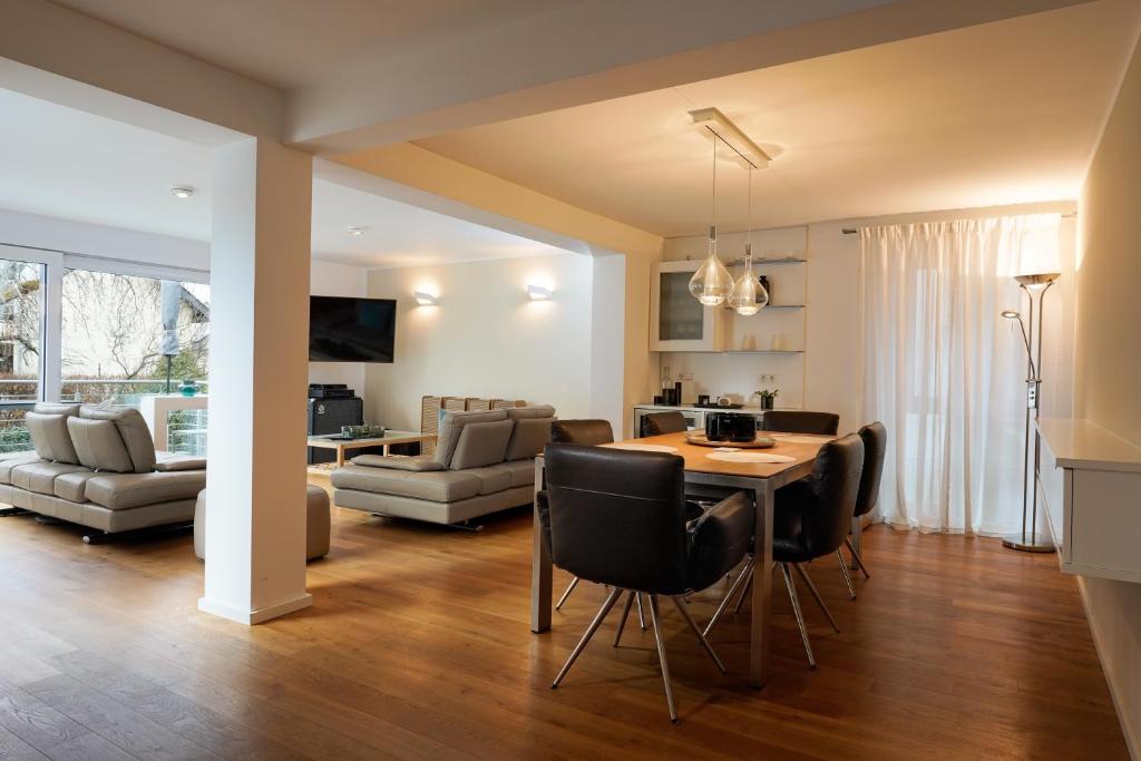 a kitchen and living room with a table and chairs at Design Apartment in Eppelheim in Eppelheim