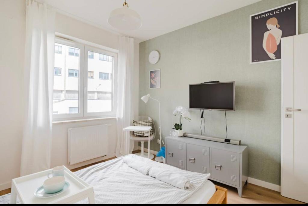 - une chambre avec un lit et une télévision à écran plat dans l'établissement Color Room Warsaw Wola, à Varsovie