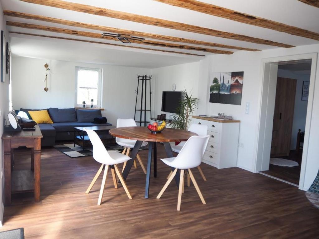 FeWo Westerwaelder Höhenluft في Langenbach bei Kirburg: غرفة معيشة مع طاولة وكراسي بيضاء