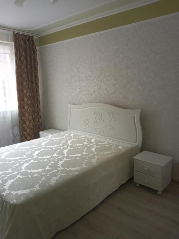 a bedroom with a white bed and a window at Шикарные апартаменты на ул.Княгини Ольги ,100К. in Lviv
