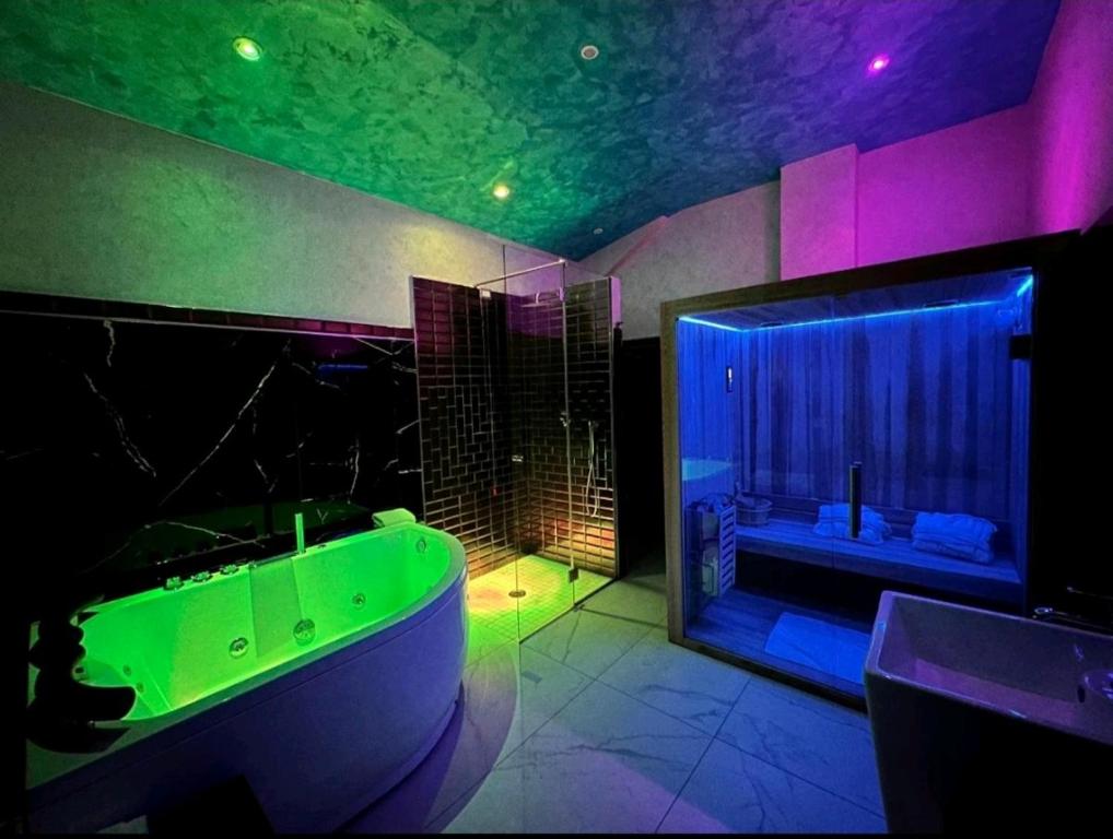 baño con bañera verde y ventana grande en Setteabbracci Suite & Apartments, en Baronissi